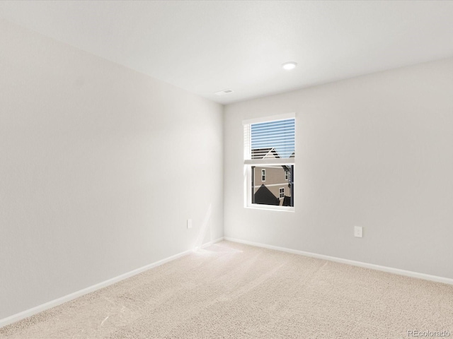 carpeted spare room featuring baseboards