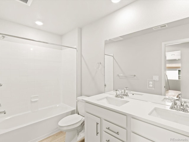 bathroom featuring a sink, visible vents, toilet, and double vanity