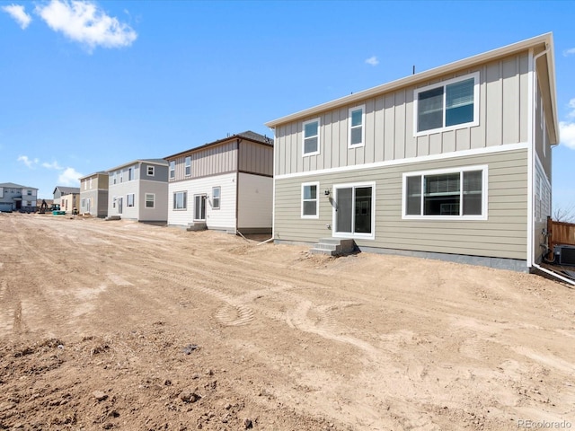 rear view of property featuring a residential view, board and batten siding, and entry steps