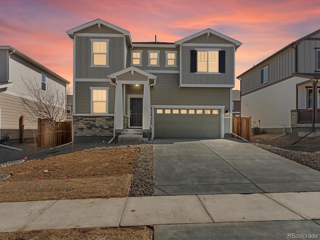 view of front of house with central air condition unit, driveway, fence, board and batten siding, and a garage