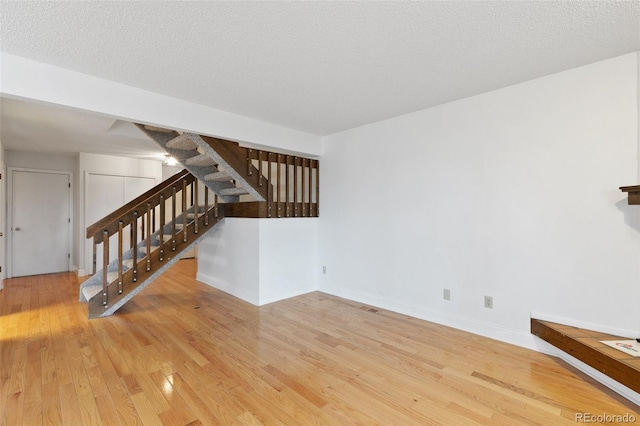 interior space with light wood-type flooring and a textured ceiling