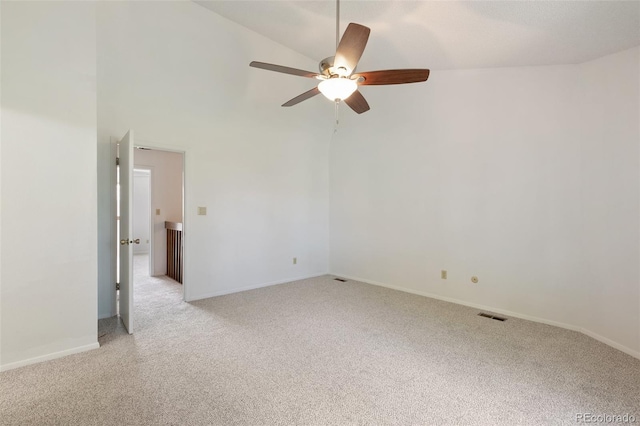 carpeted spare room with ceiling fan and high vaulted ceiling