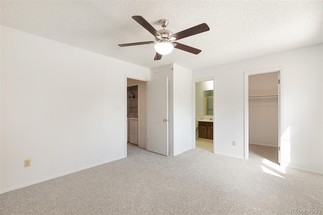 unfurnished bedroom with ceiling fan, a walk in closet, ensuite bath, a closet, and light colored carpet