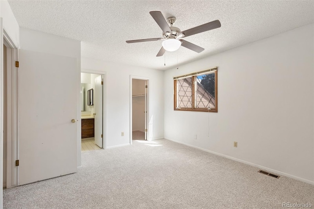 carpeted empty room featuring ceiling fan and a textured ceiling