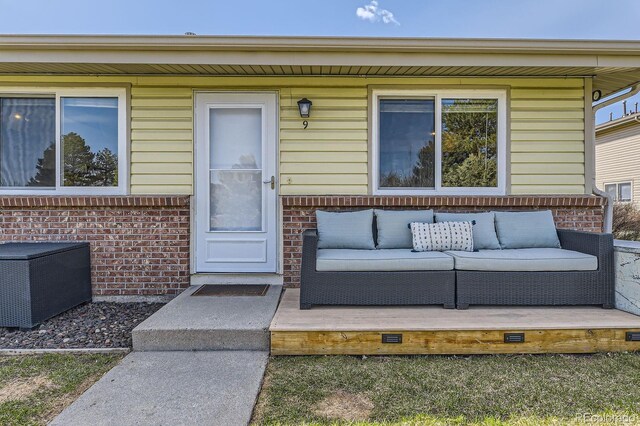 property entrance featuring brick siding and an outdoor living space