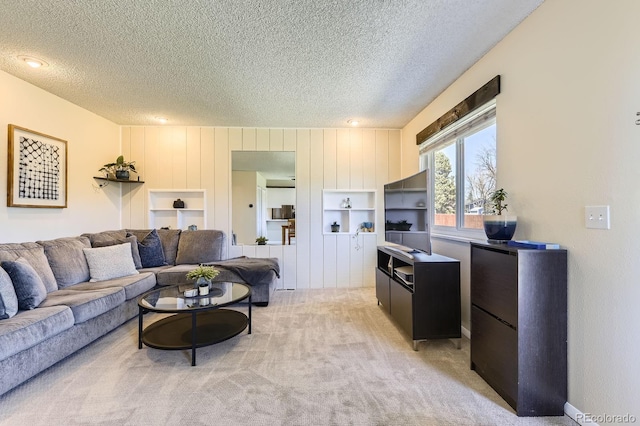 living area with light carpet and a textured ceiling