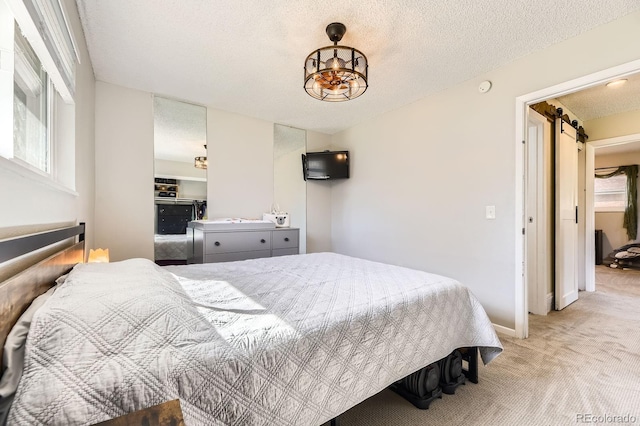 bedroom with light carpet, a textured ceiling, baseboards, and a chandelier
