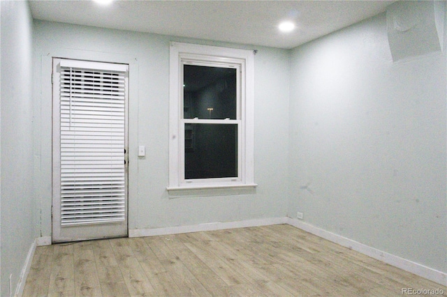 empty room featuring recessed lighting, light wood finished floors, and baseboards