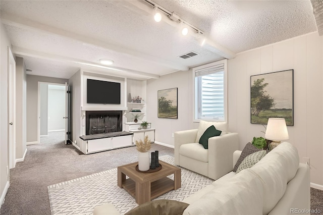 living room featuring a fireplace, light colored carpet, visible vents, a textured ceiling, and beamed ceiling