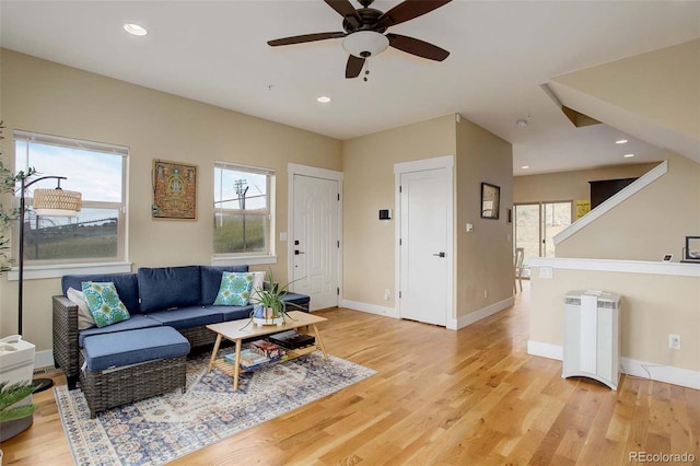 living room featuring a healthy amount of sunlight, radiator, ceiling fan, and light hardwood / wood-style flooring