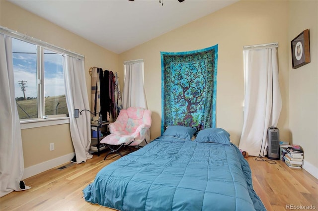 bedroom with light hardwood / wood-style flooring and lofted ceiling