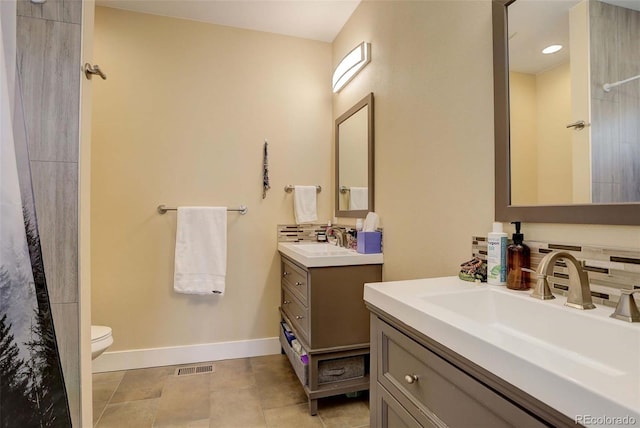 bathroom with decorative backsplash, tile patterned flooring, vanity, and toilet