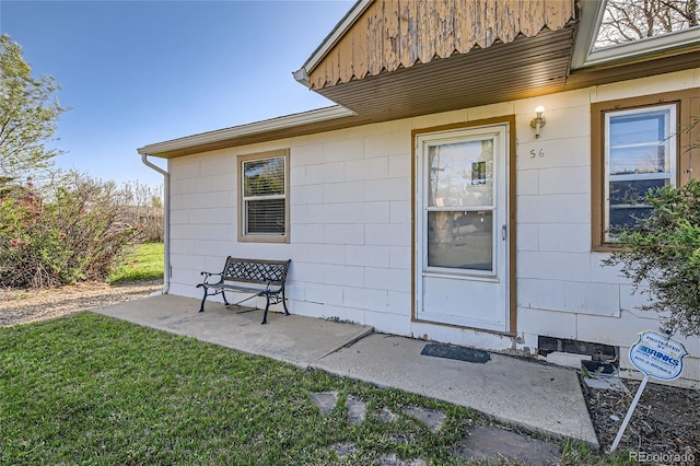 entrance to property featuring a lawn