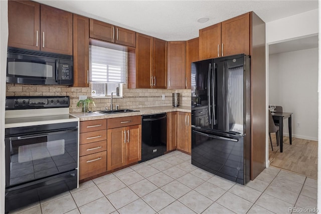 9338 W Utah Pl, Lakewood, CO 80232 - kitchen featuring black appliances, a sink, light countertops, decorative backsplash, and light tile patterned flooring