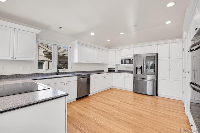 kitchen featuring white cabinetry, appliances with stainless steel finishes, sink, and light wood-type flooring