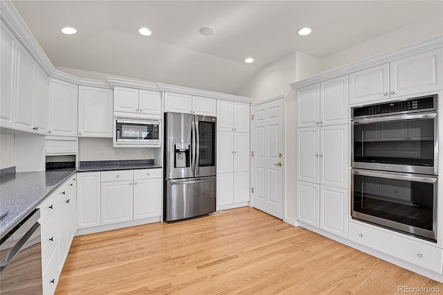 kitchen featuring light wood-style flooring, appliances with stainless steel finishes, vaulted ceiling, white cabinetry, and recessed lighting