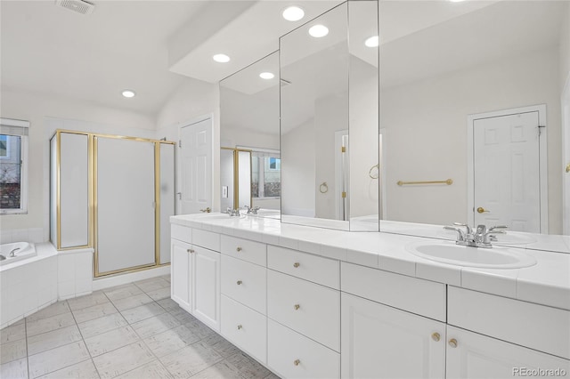 bathroom with a garden tub, a sink, a shower stall, and double vanity