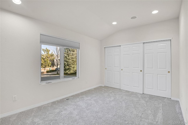 unfurnished bedroom featuring carpet floors, recessed lighting, visible vents, vaulted ceiling, and baseboards