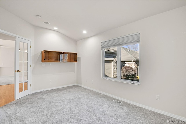 spare room featuring carpet floors, french doors, recessed lighting, lofted ceiling, and baseboards