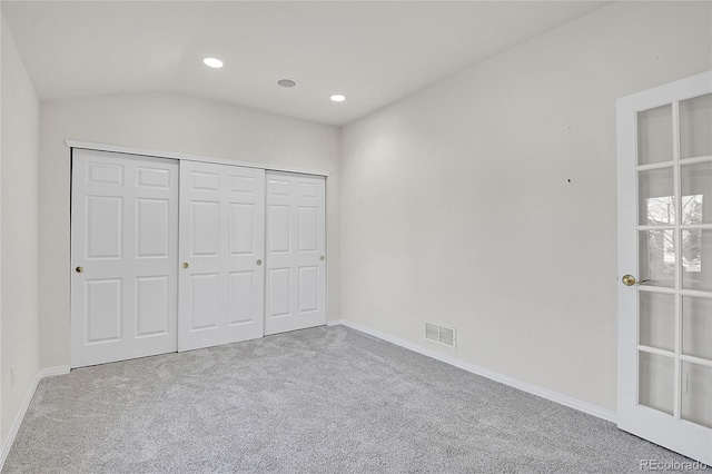 unfurnished bedroom featuring baseboards, visible vents, lofted ceiling, carpet floors, and recessed lighting