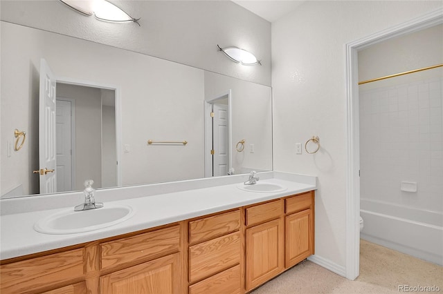 full bathroom with double vanity, a sink, and toilet