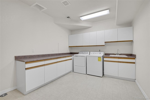 clothes washing area with cabinet space, visible vents, a sink, and washing machine and clothes dryer