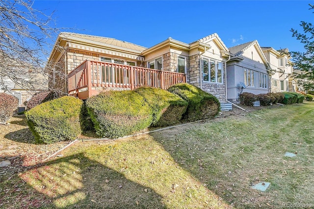 view of front of home featuring stone siding and a deck