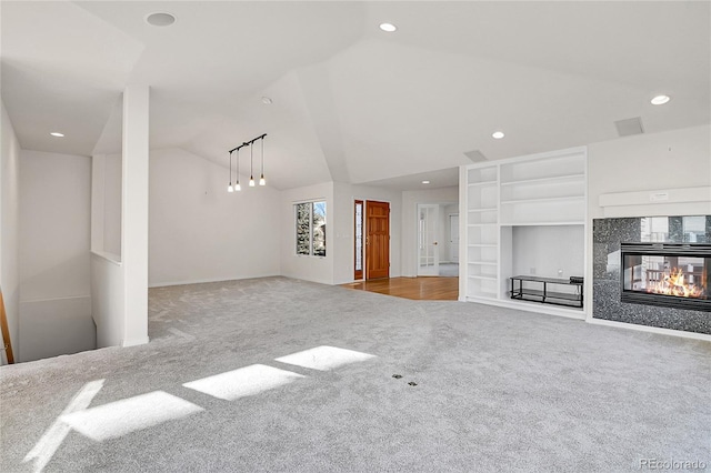 unfurnished living room featuring light carpet, vaulted ceiling, and a multi sided fireplace