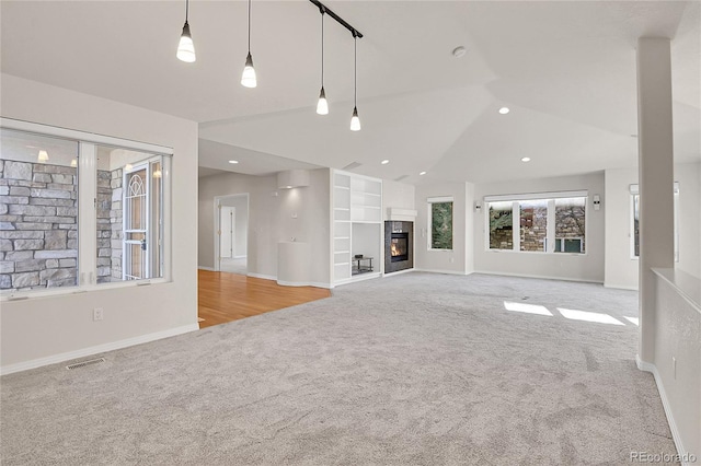 unfurnished living room with light colored carpet and lofted ceiling