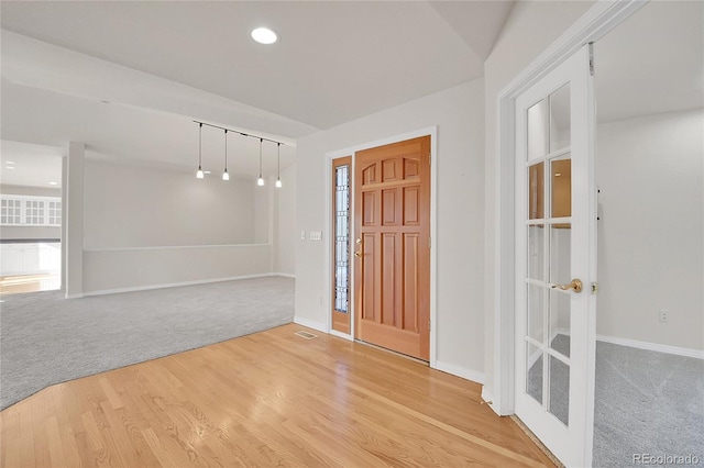 entryway featuring recessed lighting, baseboards, light carpet, and light wood finished floors