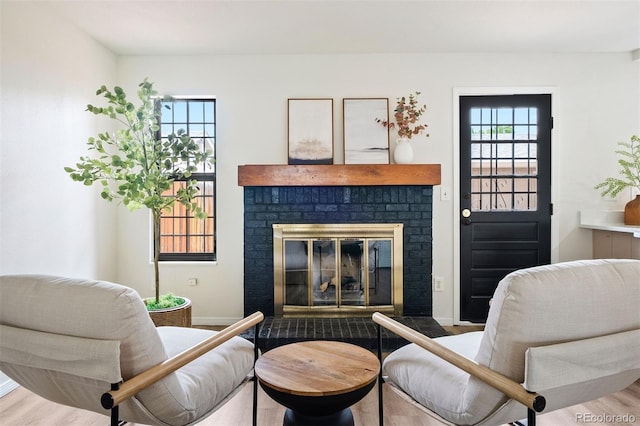 sitting room with baseboards, a fireplace, and wood finished floors