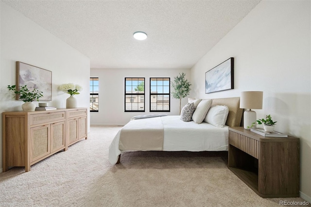 bedroom with a textured ceiling and light carpet