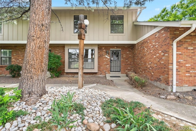 view of front of home featuring brick siding and board and batten siding