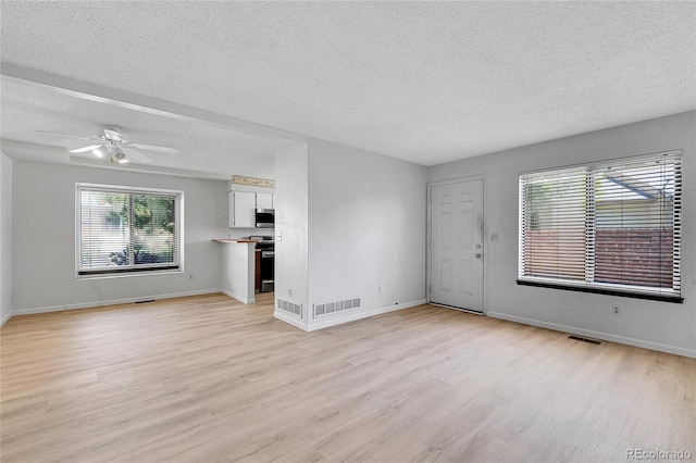 10143 Quivas St, Thornton, CO 80260 - unfurnished living room featuring light wood finished floors, a textured ceiling, and a ceiling fan