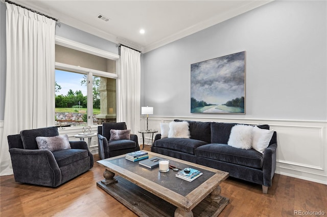 living room with hardwood / wood-style flooring and ornamental molding