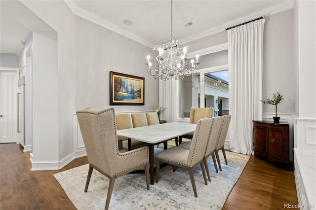 dining room with a notable chandelier, ornamental molding, and hardwood / wood-style flooring