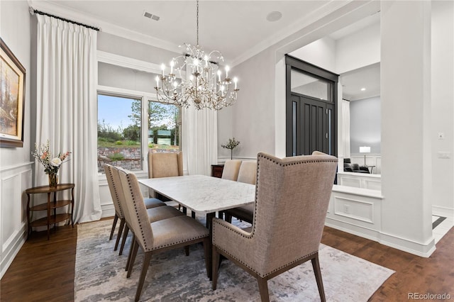 dining room with a notable chandelier, dark wood-type flooring, and ornamental molding