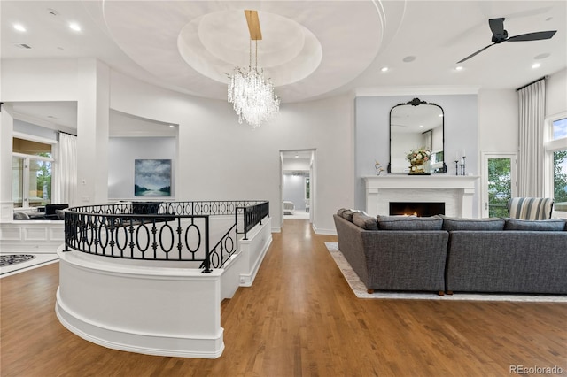 hall with an inviting chandelier, a raised ceiling, and hardwood / wood-style floors