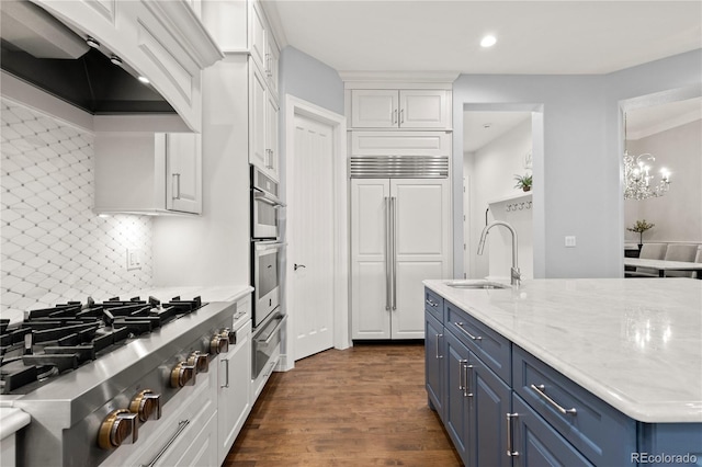 kitchen featuring backsplash, appliances with stainless steel finishes, white cabinets, dark wood-type flooring, and blue cabinets