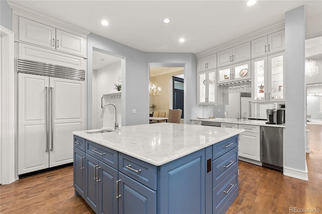 kitchen featuring built in refrigerator, sink, a kitchen island with sink, white cabinets, and dark hardwood / wood-style flooring