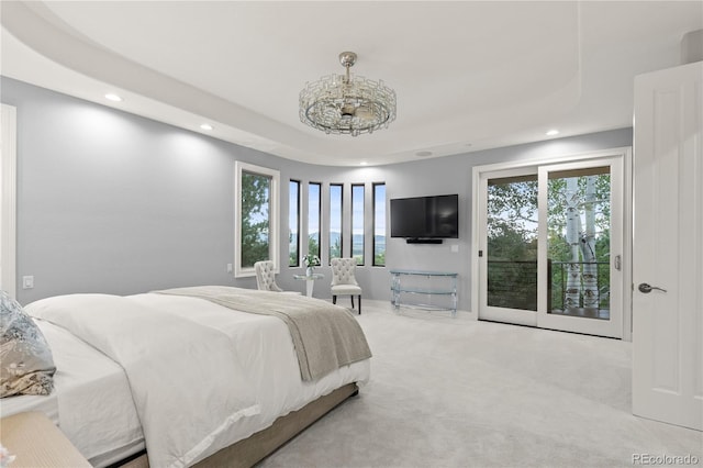 carpeted bedroom featuring access to outside and a tray ceiling