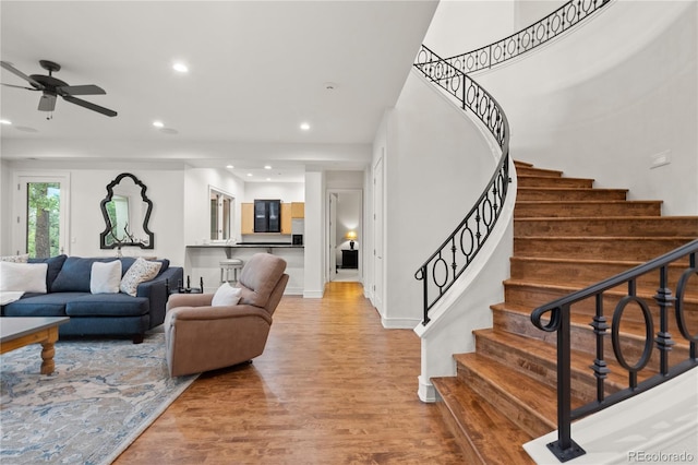 living room featuring light hardwood / wood-style flooring and ceiling fan