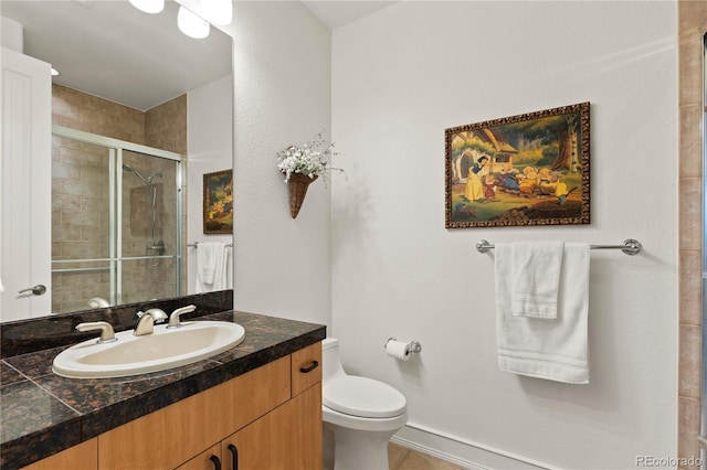 bathroom with vanity, a shower with shower door, and toilet