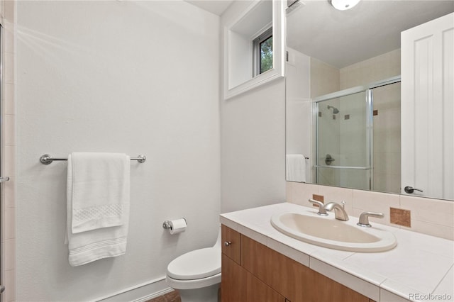 bathroom featuring vanity, toilet, and walk in shower