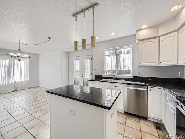 kitchen with stainless steel appliances, sink, pendant lighting, white cabinets, and a center island