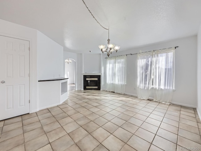 unfurnished living room featuring light tile patterned floors and an inviting chandelier