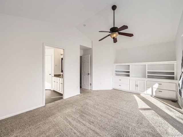 unfurnished bedroom featuring ensuite bath, ceiling fan, high vaulted ceiling, and dark carpet