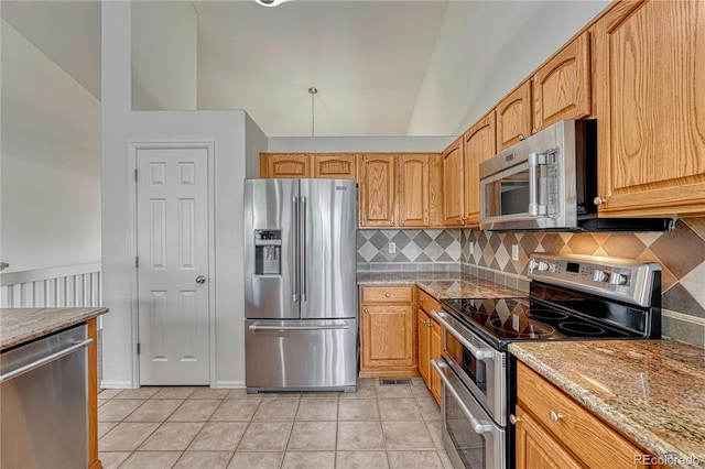 5350 S Quail Way, Littleton, CO 80127 - kitchen with stainless steel appliances, tasteful backsplash, light tile patterned flooring, and vaulted ceiling