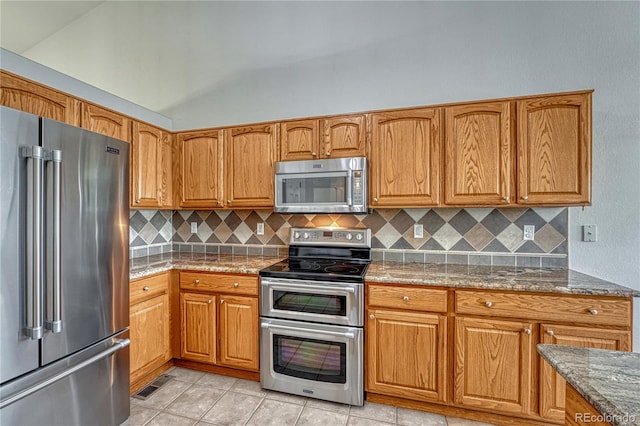 5350 S Quail Way, Littleton, CO 80127 - kitchen featuring appliances with stainless steel finishes, stone counters, decorative backsplash, light tile patterned floors, and brown cabinets