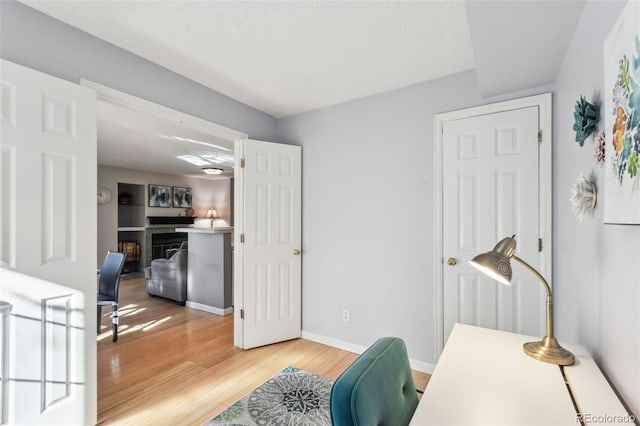 office space featuring a fireplace, hardwood / wood-style floors, and a textured ceiling